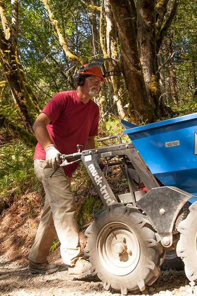 a man working with mechanized trail equipment